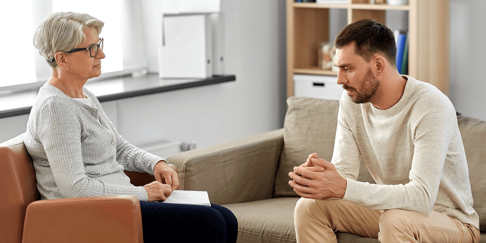 Male patient speaking with a female clinician.